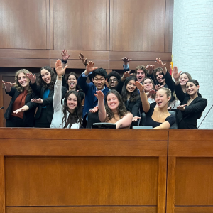 Big group of LitiGator team members doing the Gator chomp with their arms at the Judge's bench 