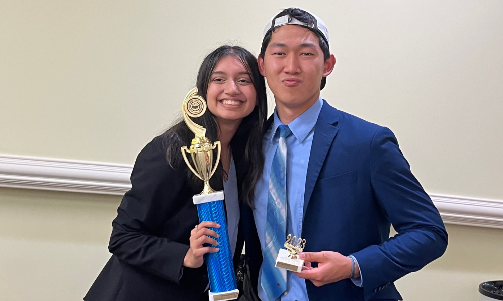 Two LitiGator team members holding winning trophy during the regionals tournament.