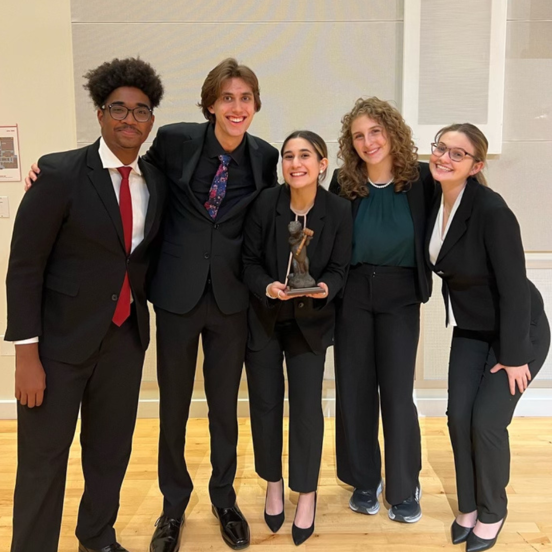 Group of some other team members from the LitiGators holding the gator trophy they won as the first place team at the UF Swamp Invitational. 